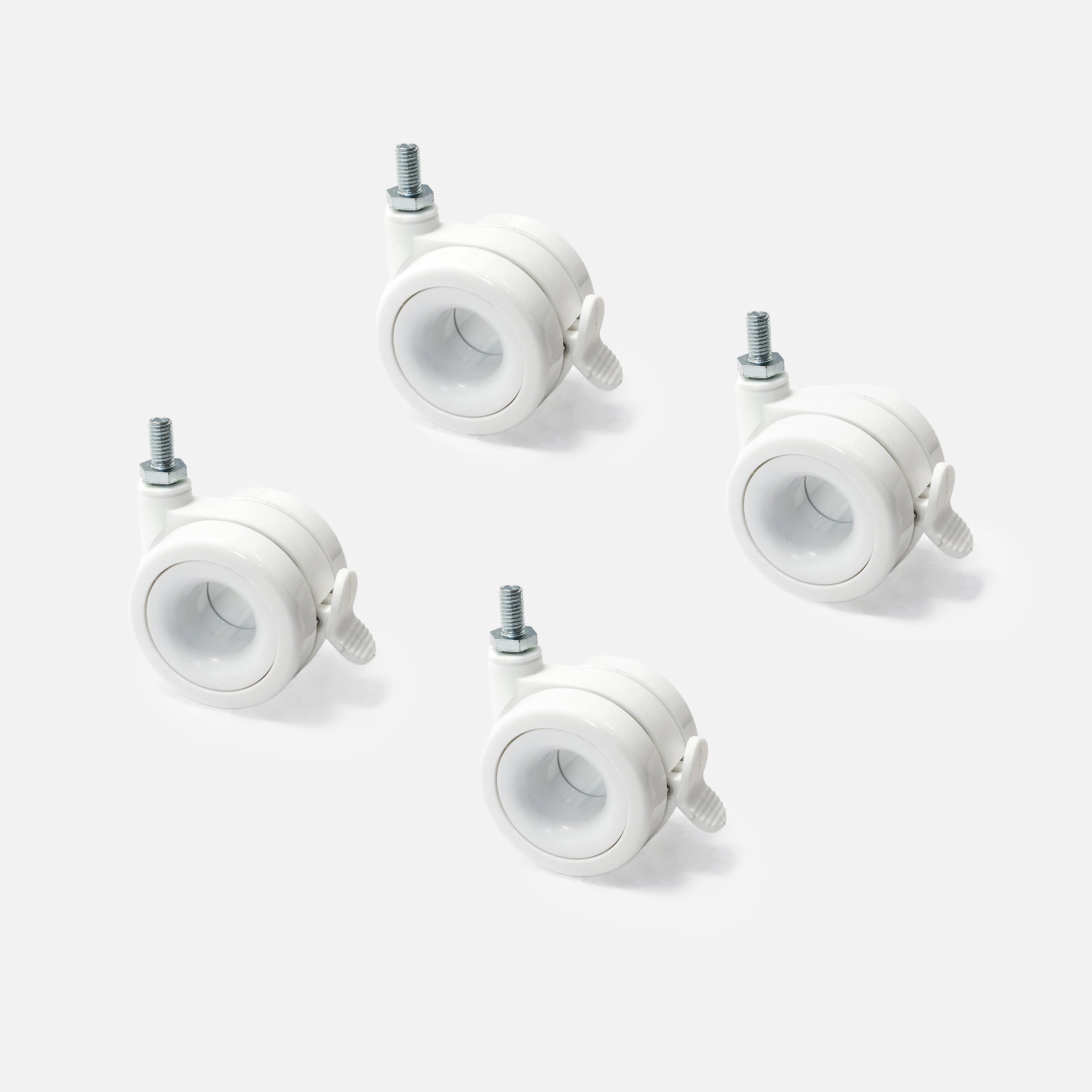 Four white caster wheels on a light gray background