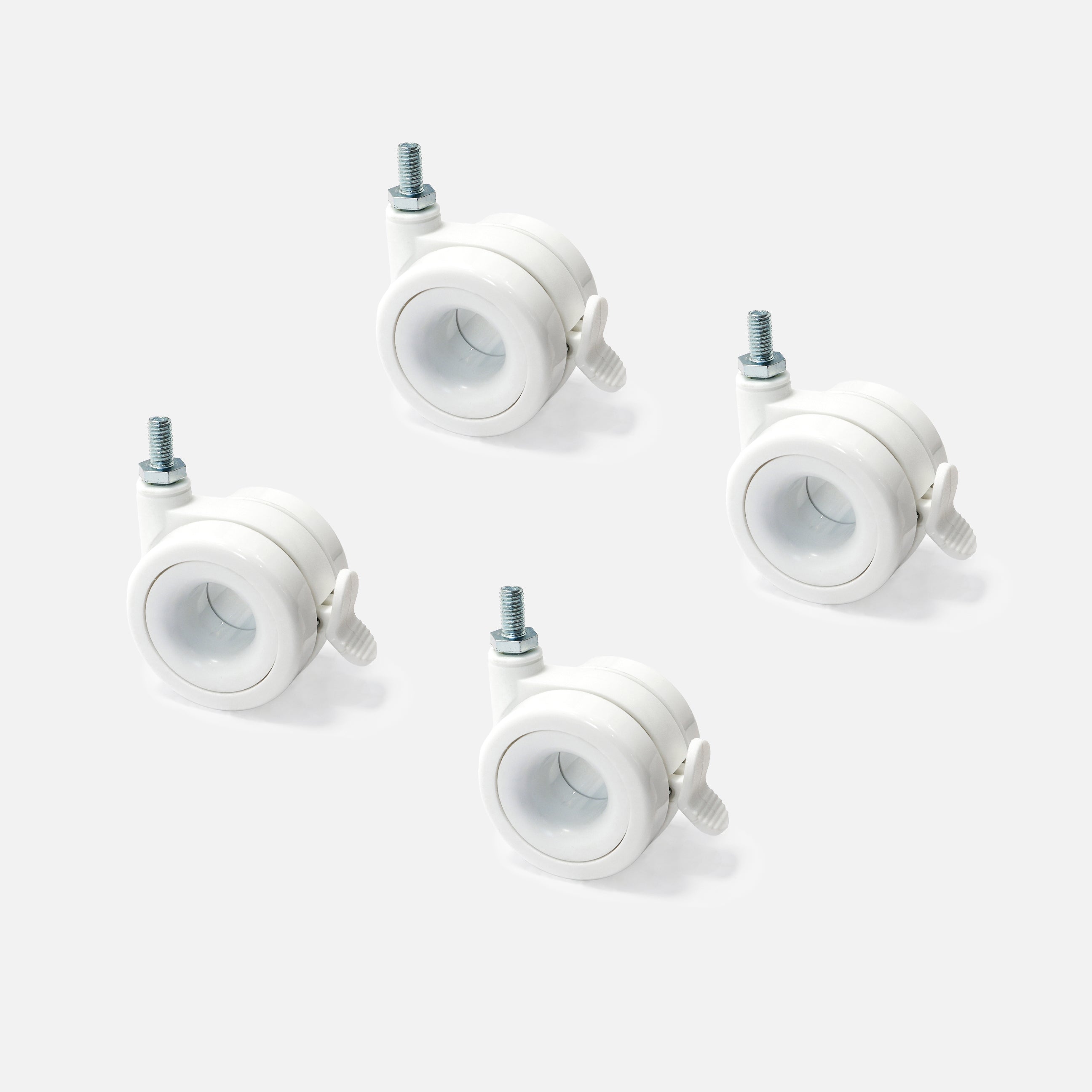 Four white caster wheels on a light gray background