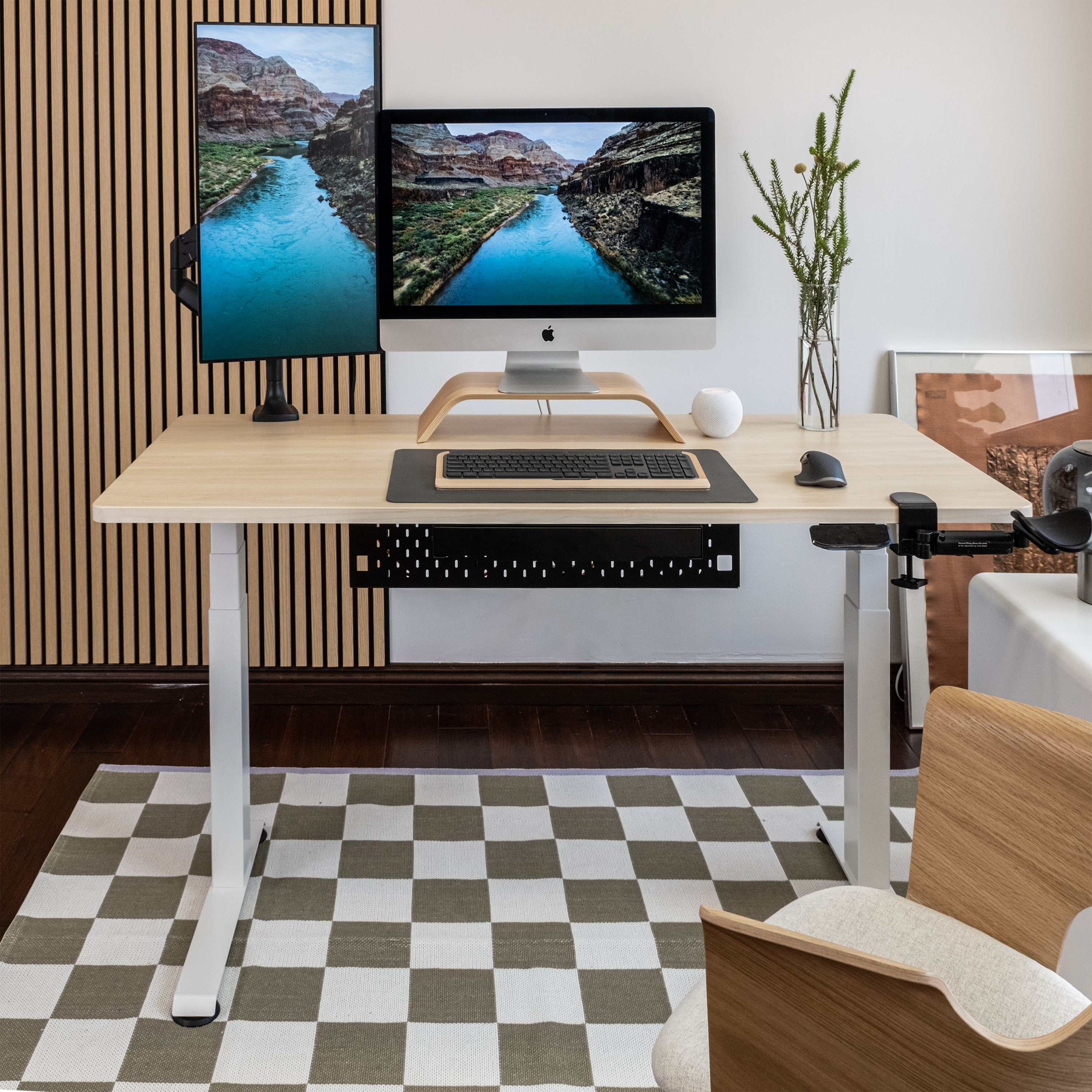 Modern home office with a standing desk, computer setup, and decorative elements.