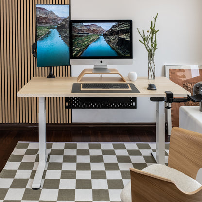 Modern home office with a standing desk, computer setup, and decorative elements.
