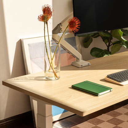 Modern office desk with a computer monitor, keyboard, and decorative elements.