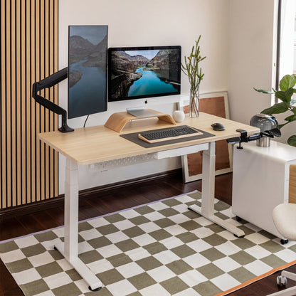 Modern home office setup with a standing desk, computer monitors, and office chair.