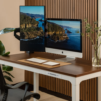 Modern office setup with dual monitors on a wooden desk.
